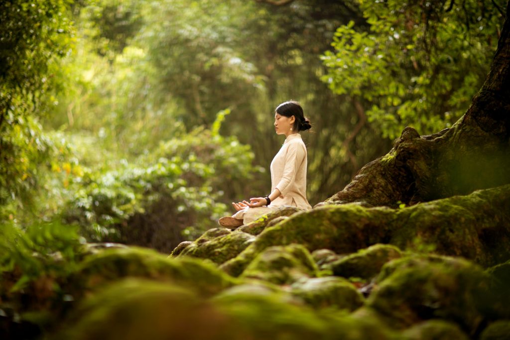 a woman doing yoga in the forest